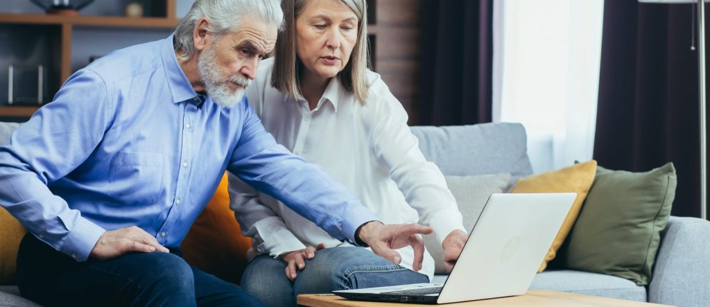 couple âgé regardant sur un ordinateur pour consulter l'espace adhérent de la MFCF