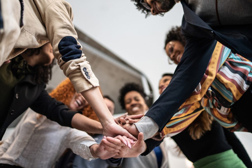 groupe de personnes en cercle joignant leurs mains au milieu exprime leur solidarité